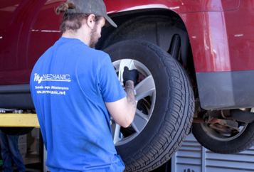 Auto repair technician removing a car wheel