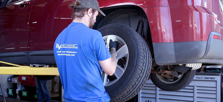 Auto repair technician removing a car wheel