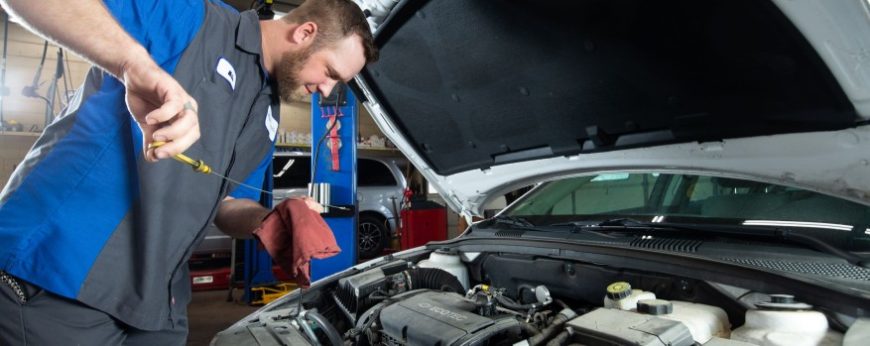 Technician Mike checks the oil level in a customer's car