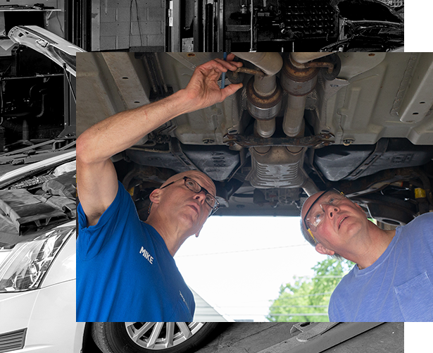Auto technicians looking under a car to check for damages